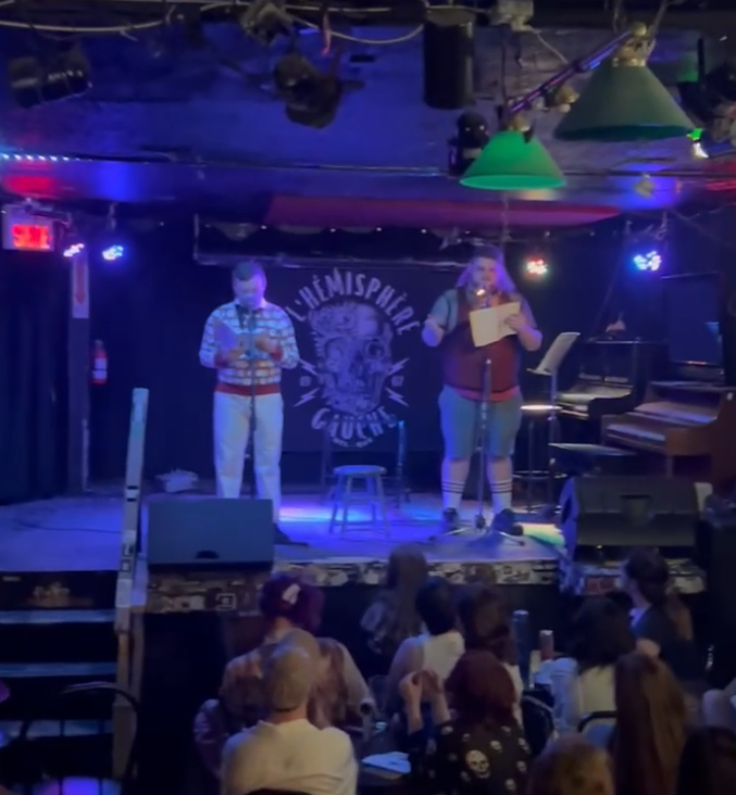 A photo of Dave and I on-stage at the JRG Open Mic. It's a small dingy bar venue, with a decent crowd all seated at tables in a pit below the stage.